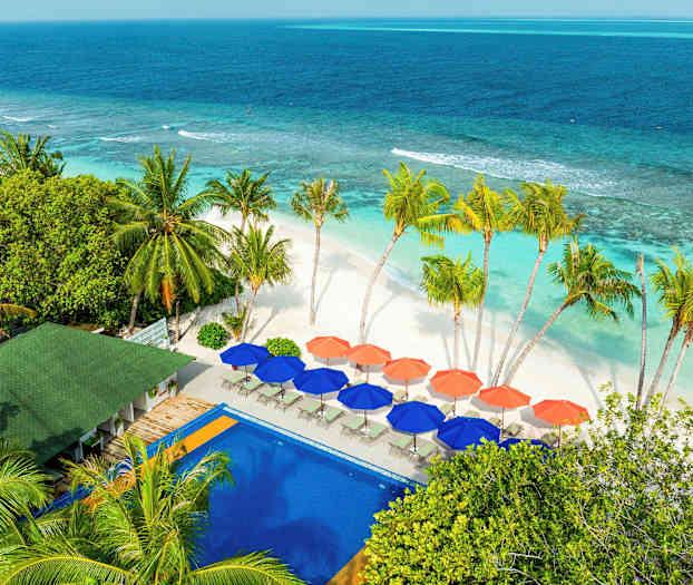 Ranta, jossa valkoinen hiekka, turkoosin sävyinen vesi ja palmuja. Värikkäitä varjoja ja uima-allas näkyvät etualalla. (Tekoälyn luoma teksti)