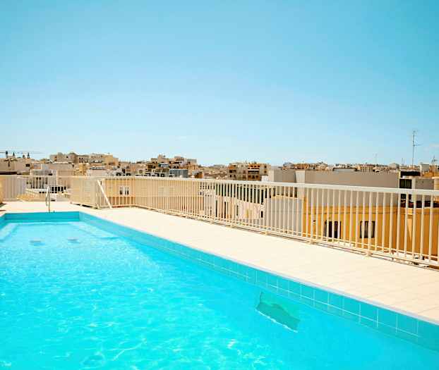 Ulkouima-allas kirkkaalla vedellä kattoterassilla. Taustalla näkyy kaupunkiasutusta kirkkaan sinisen taivaan alla. (Tekoälyn luoma teksti)