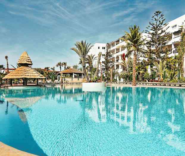 Uima-allas, jonka ympärillä on varjoja ja palmuja. (Tekoälyn luoma teksti)