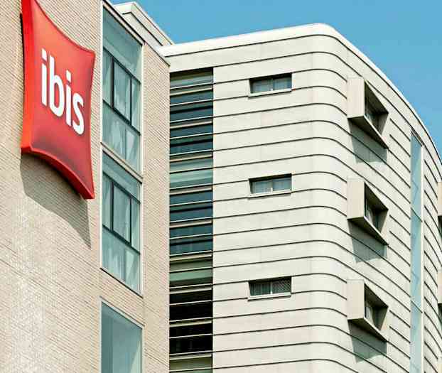 Useita kerroksia nykyaikaisesta rakennuksesta, jossa on selkeä punainen ibis-kyltti. (Tekoälyn luoma teksti)
