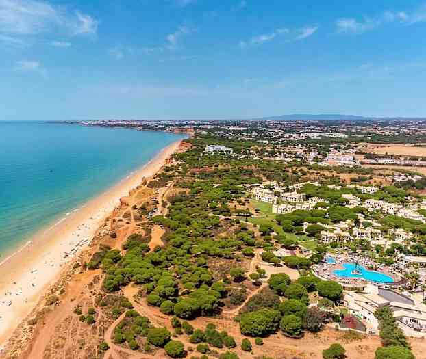 Ilmakuva rannikkoalueesta, jossa on ranta, meri ja vehreyttä. (Tekoälyn luoma teksti)