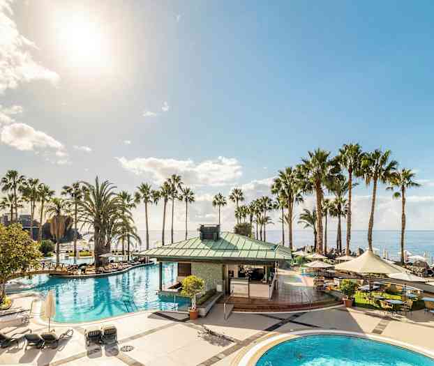 Uima-allasalue palmuineen ja merinäköalalla kirkkaana päivänä. (Tekoälyn luoma teksti)