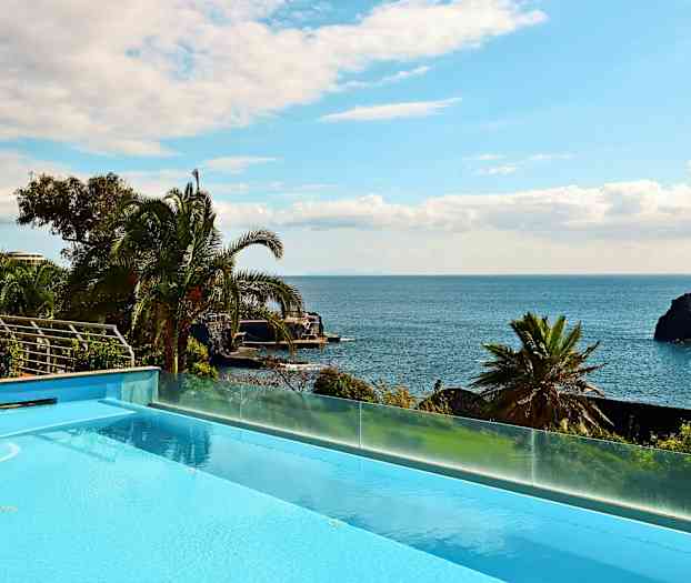 Näkymä uima-altaasta, taustalla meri ja palmuja. (Tekoälyn luoma teksti)