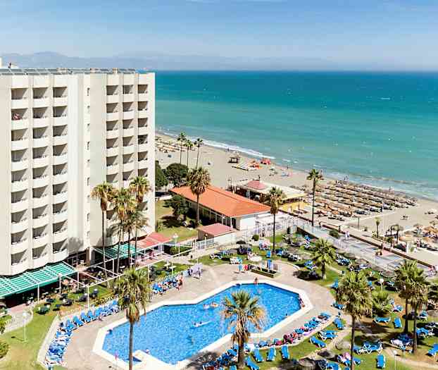 Hotellissa uima-allas ja aurinkotuoleja lähellä hiekkarantaa meren äärellä. (Tekoälyn luoma teksti)