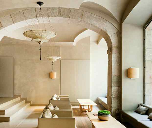 Tyylikkäästi sisustettu huone, jossa on kaariholveja, moderneja huonekaluja ja suuret ikkunat kadulle päin. (Tekoälyn luoma teksti)