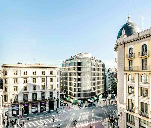 Kaupunkikatu, jota ympäröi useita eri arkkitehtuurityyliä edustavia rakennuksia. (Tekoälyn luoma teksti)