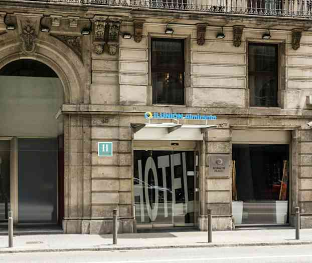 Ilunion Almirante -hotellin ulkoseinä, jossa sisäänkäynti ja kyltti. (Tekoälyn luoma teksti)