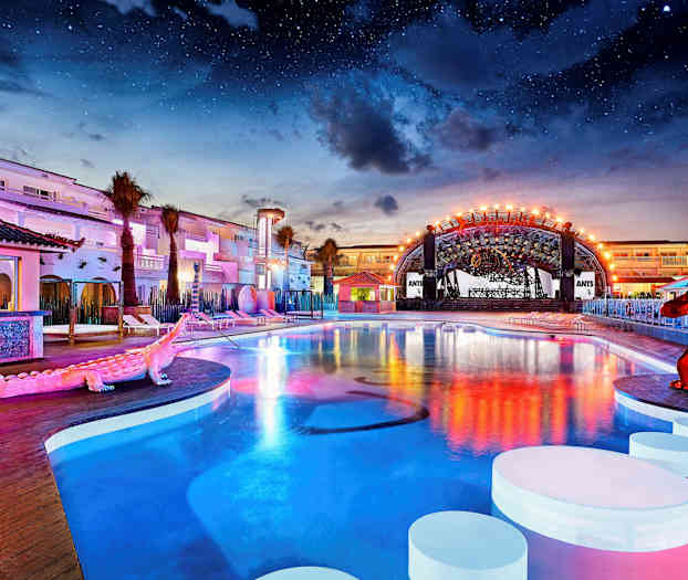 Ulkoallas valaistun hotellikompleksin yhteydessä tähtitaivaan alla. (Tekoälyn luoma teksti)