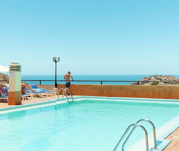 Ulkouima-allas merinäkymällä, aurinkotuoleja ja aurinkovarjoja. (Tekoälyn luoma teksti)