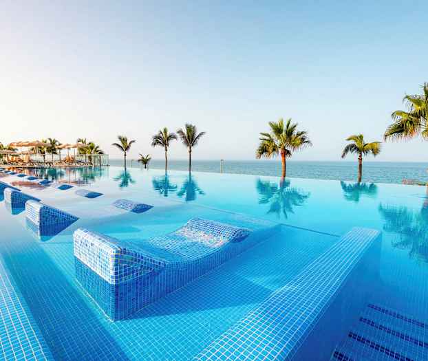 Infinity-allas, josta on näkymä merelle ja ympäröiviin palmuihin. (Tekoälyn luoma teksti)