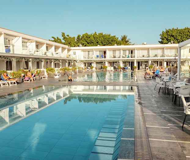 Hotellialue, jossa uima-allas, aurinkotuoleja ja istumapaikkoja. (Tekoälyn luoma teksti)