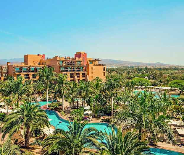 Lomakohde, jossa on uima-altaita ja ympärillä palmuja, sekä rakennuksia taustalla. (Tekoälyn luoma teksti)