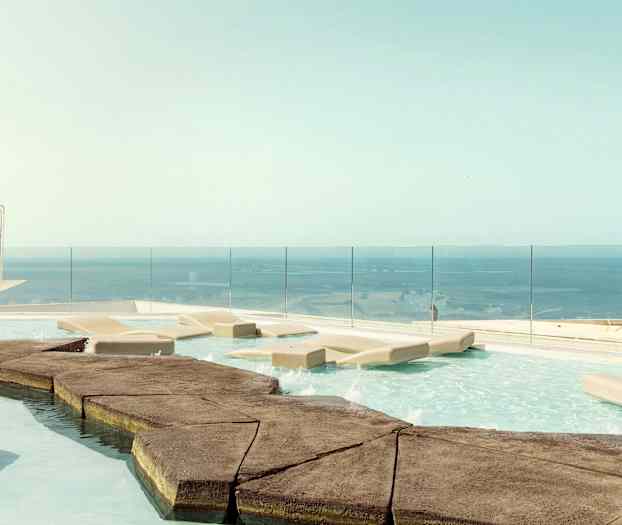 Infinity-allas aurinkotuoleilla ja merinäköalalla. (Tekoälyn luoma teksti)