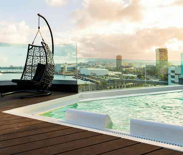 Kattouima-allasalue, jossa roikkutuoli ja panoraamanäkymä kaupunkiin. (Tekoälyn luoma teksti)