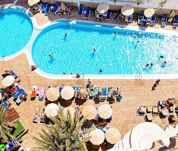 Ulkouima-allas, jonka vieressä aurinkotuoleja ja varjoja. (Tekoälyn luoma teksti)