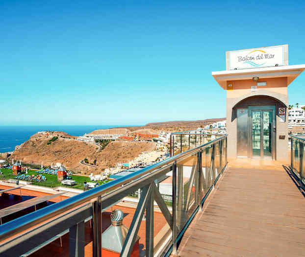 Lasihissi kävelysillalla, josta on näköala maisemaan ja mereen. (Tekoälyn luoma teksti)