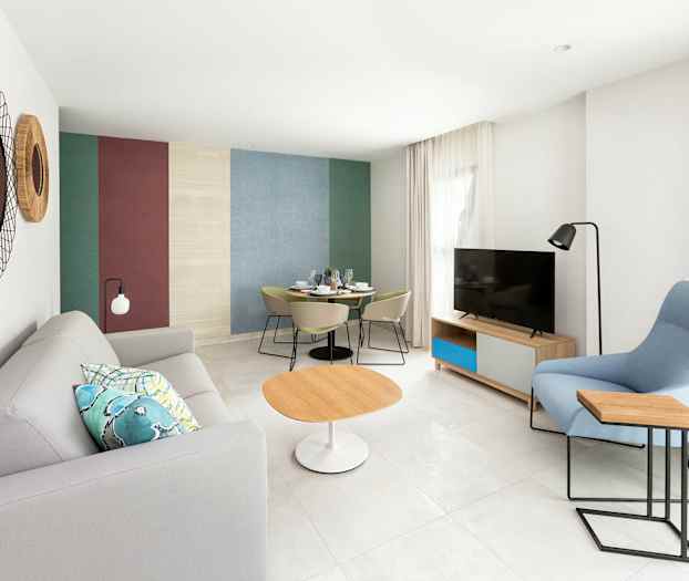 Modernisti sisustettu olohuone, jossa sohva, pöytä ja televisio. (Tekoälyn luoma teksti)