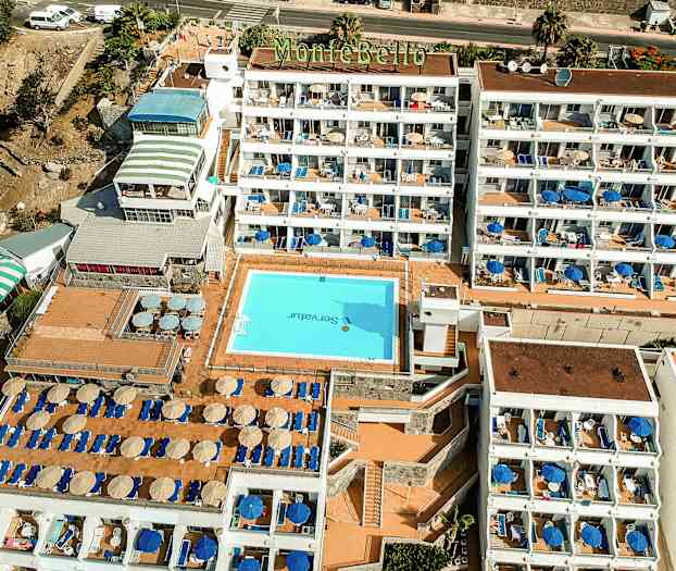 Ilmakuva Montebello-hotellista, jossa uima-allas ja aurinkotuoleja. (Tekoälyn luoma teksti)