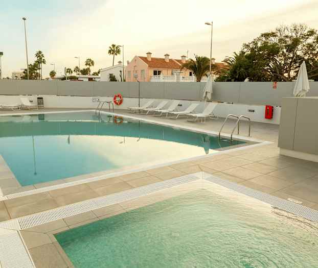 Ulkouima-allas, jonka vieressä on aurinkotuoleja. (Tekoälyn luoma teksti)