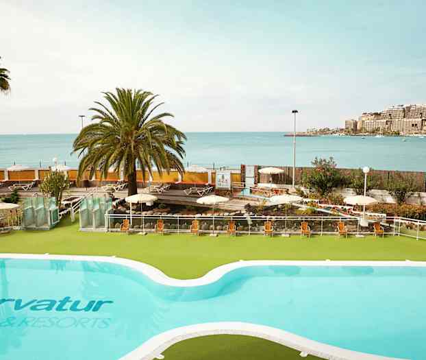 Uima-allas, josta on näkymä merelle ja aurinkoterassi aurinkotuoleilla. (Tekoälyn luoma teksti)