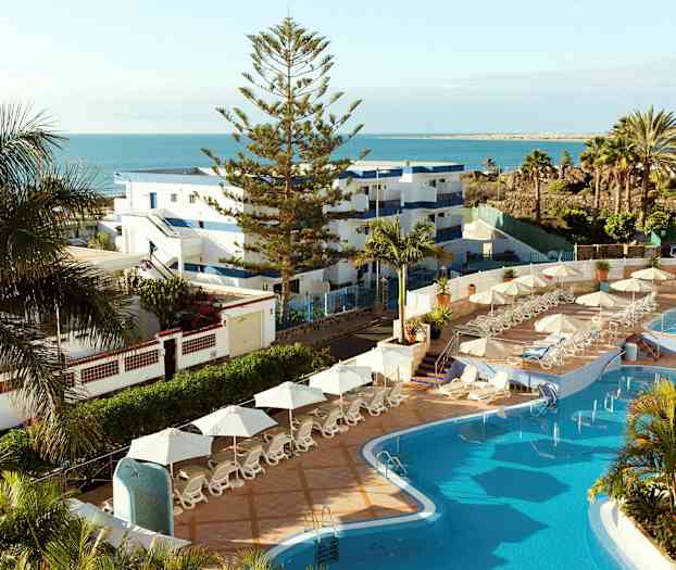 Kuva hotellialueesta, jossa on uima-allas, aurinkotuoleja ja näkymä merelle. (Tekoälyn luoma teksti)