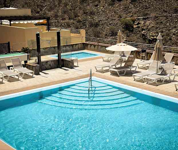 Ulkoallas, jonka vieressä on aurinkotuoleja ja aurinkovarjoja. (Tekoälyn luoma teksti)