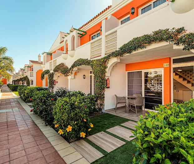 Rivistö lomahuoneistoja, joissa yksityisiä terasseja ja puutarha. (Tekoälyn luoma teksti)