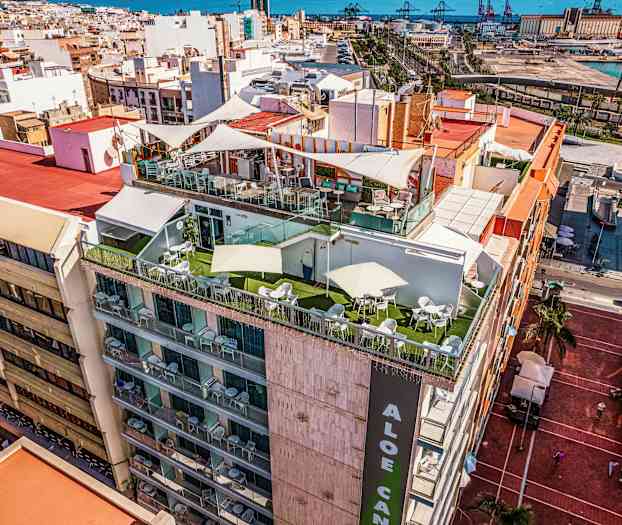 Rakennus, jossa on terasseja ylhäällä, ympärillä kaupunki ja taustalla meri. (Tekoälyn luoma teksti)