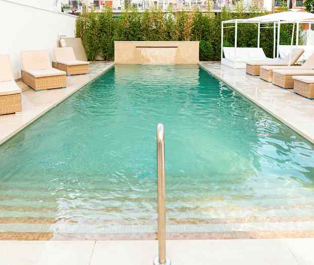 Uima-allas, jonka reunalla on aurinkotuoleja. (Tekoälyn luoma teksti)