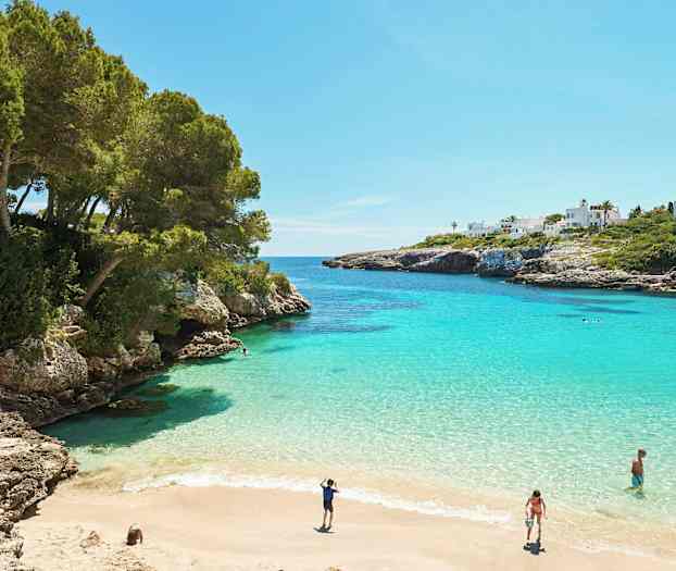 Lahti, jossa on turkoosia vettä, hiekkaranta ja ympäröiviä kallioita. (Tekoälyn luoma teksti)