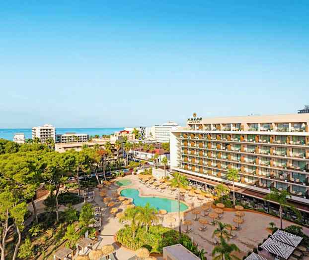 Näkymä hotellialueesta uima-altaalla, vihreillä alueilla ja merellä taustalla. (Tekoälyn luoma teksti)