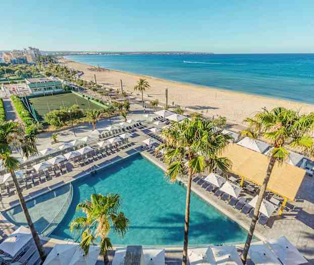 Näkymä altaalle, jossa on aurinkotuoleja ja -varjoja rannalla kaupunkiympäristössä. (Tekoälyn luoma teksti)