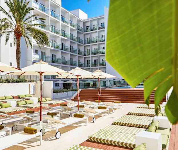 Hotellin uima-allasalue aurinkotuoleilla, varjoilla ja taustalla kerrostalo. (Tekoälyn luoma teksti)