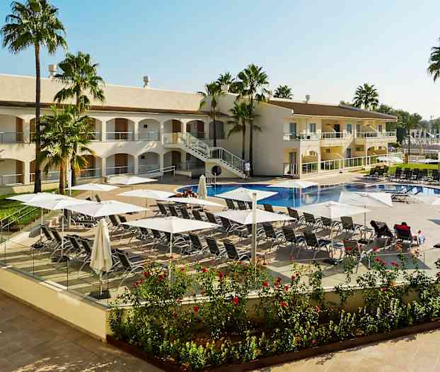 Kuva hotellin uima-altaasta, jossa aurinkotuoleja ja aurinkovarjoja, ympärillä palmuja ja hotelli. (Tekoälyn luoma teksti)