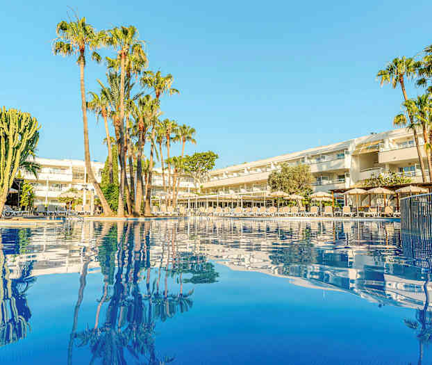 Kuva hotellista, jossa on palmuja uima-altaan vieressä. (Tekoälyn luoma teksti)