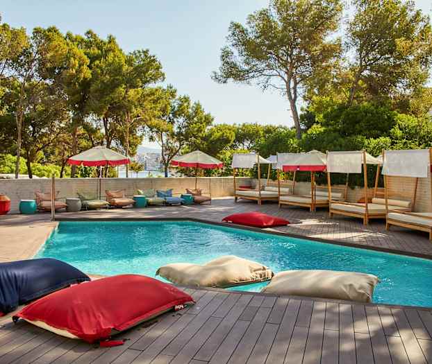 Ulkoallas, jota ympäröivät aurinkotuolit ja aurinkovarjot. (Tekoälyn luoma teksti)