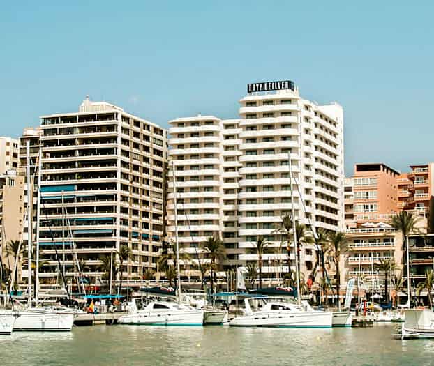 Kuva satamasta, jossa on purjeveneitä ja korkeita rakennuksia taustalla. (Tekoälyn luoma teksti)