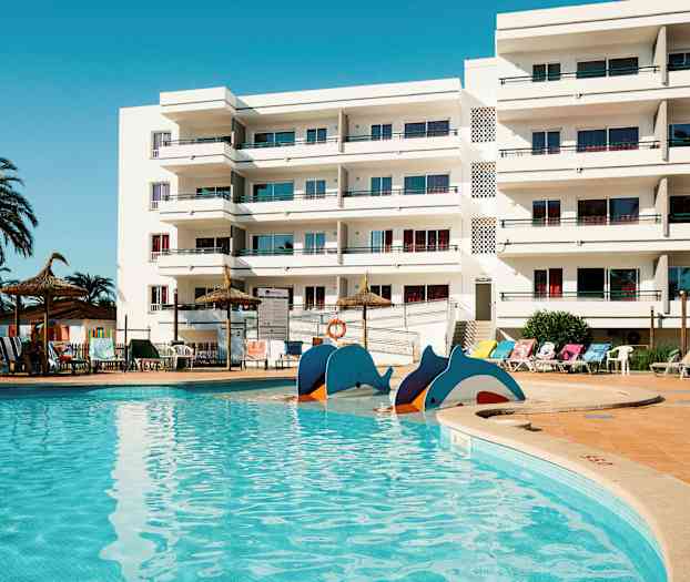 Uima-allas valkoisen parvekkeellisen rakennuksen edessä. (Tekoälyn luoma teksti)