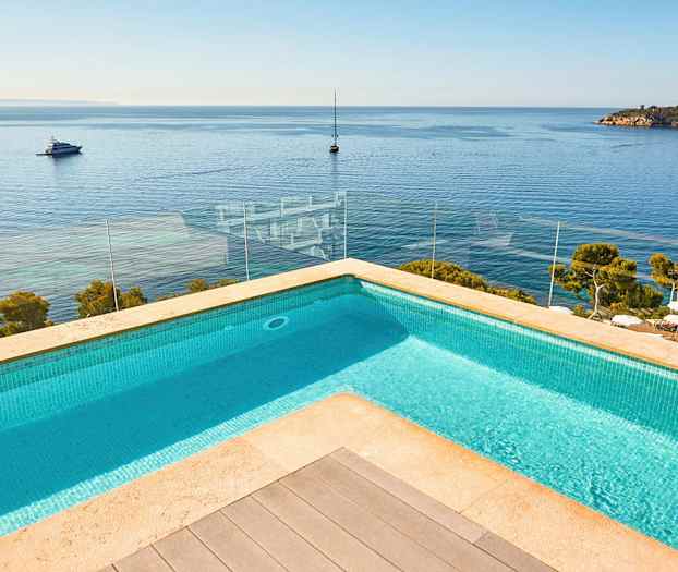 Kuvan uima-allas, josta on näkymä merelle ja veneisiin. (Tekoälyn luoma teksti)