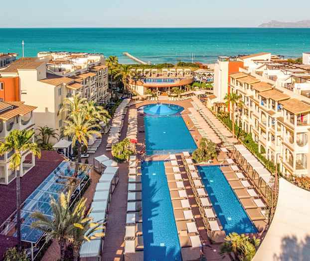 Näkymä lomakeskukselle uima-altaineen ja taustalla oleva meri. (Tekoälyn luoma teksti)