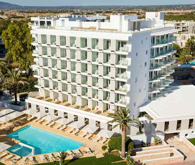 Moderni hotellirakennus, jossa uima-allas ja aurinkotuoleja sen ympärillä, ympäröitynä puilla ja vehreydellä. (Tekoälyn luoma teksti)