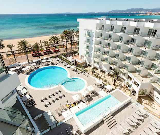 Hotellialue uima-altaineen ja aurinkotuoleineen, taustalla ranta ja meri. (Tekoälyn luoma teksti)