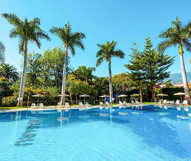 Kuva ulkouima-altaasta, jonka ympärillä on aurinkotuoleja, varjoja ja palmuja. (Tekoälyn luoma teksti)