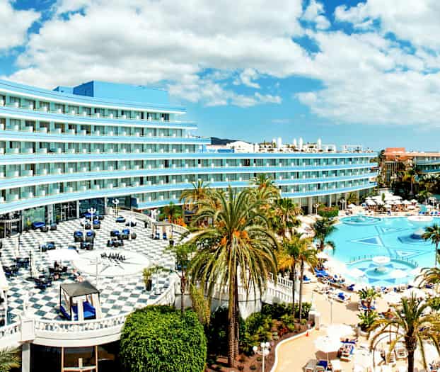 Hotellin kuva, jossa on uima-allas ja palmupuita. (Tekoälyn luoma teksti)