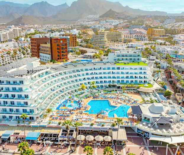 Näköala lomakompleksiin uima-altaineen ja ympäröivine rakennuksineen vuoristoisessa ympäristössä. (Tekoälyn luoma teksti)