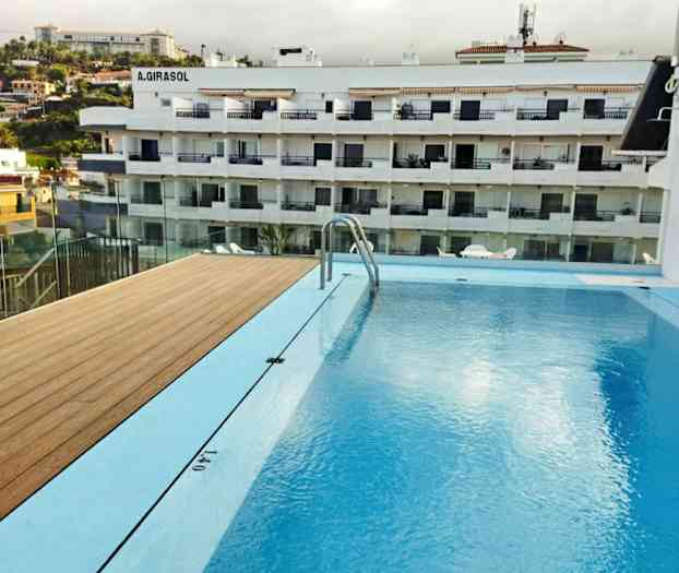 Kuva uima-altaasta, jonka taustalla näkyy asuintalo. (Tekoälyn luoma teksti)