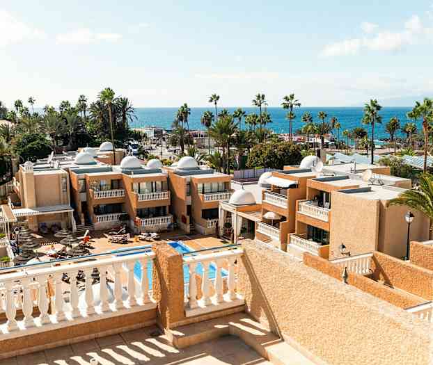 Näkymä hotellirakennuksista ja uima-altaasta, taustalla meri. (Tekoälyn luoma teksti)