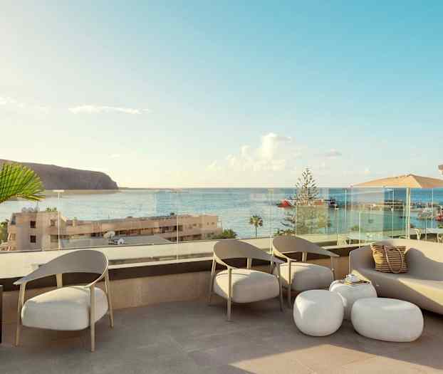 Terassi, jossa istumapaikkoja ja näkymä merelle ja satamaan. (Tekoälyn luoma teksti)