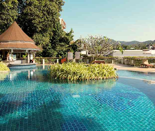 Uima-allasalue, jossa kasvien saari ja puutarhakalusteet katoksessa. (Tekoälyn luoma teksti)