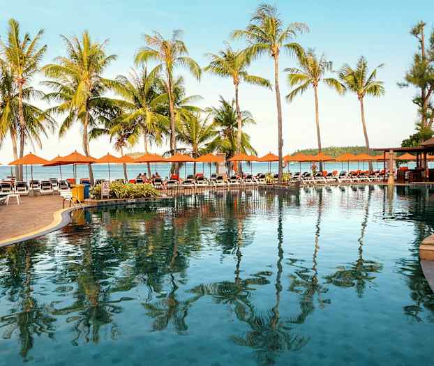 Uima-allas-alue aurinkotuoleilla, palmuja ja taustalla meri. (Tekoälyn luoma teksti)